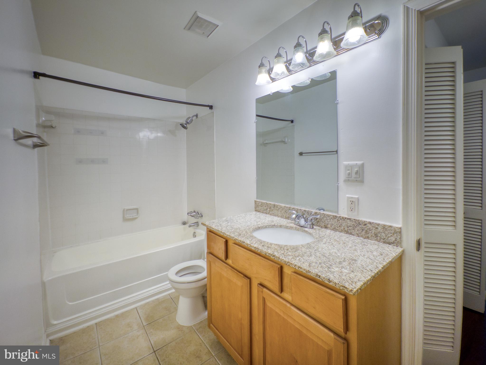 3178 Summit Square Drive, Unit 3C9 Oakton, VA 22124 - Photo 16 of 21 a bathroom with a granite countertop sink a toilet and shower