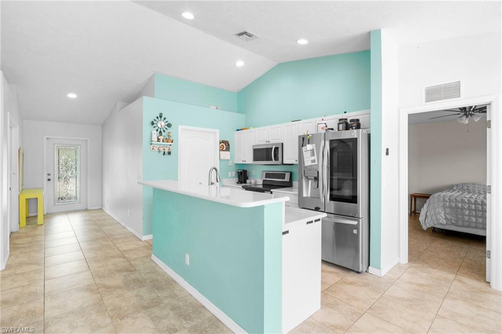 15601 Cemetery Road Fort Myers, FL 33905 - Photo 3 of 20 Kitchen with stainless steel appliances, light countertops, white cabinets, light tile patterned floors, and baseboards