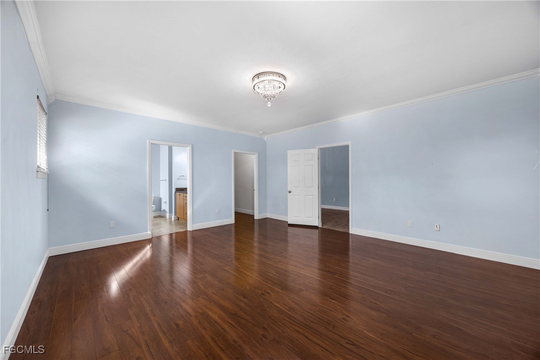 360 18th Street Northeast Naples, FL 34120 - Photo 12 of 37 a view of an empty room with wooden floor and a window