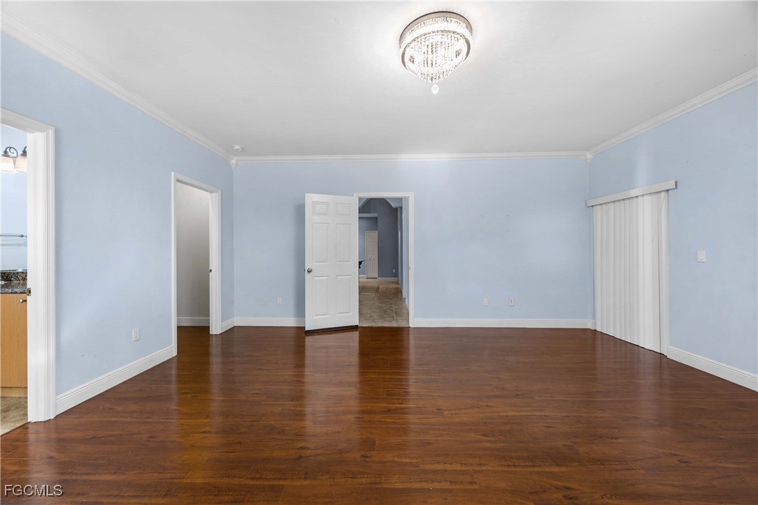 360 18th Street Northeast Naples, FL 34120 - Photo 13 of 37 an empty room with wooden floor and windows