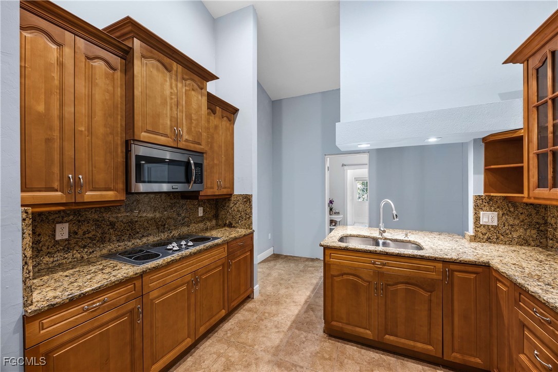 360 18th Street Northeast Naples, FL 34120 - Photo 15 of 37 a kitchen with stainless steel appliances granite countertop a sink stove and microwave