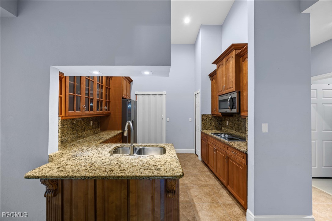 360 18th Street Northeast Naples, FL 34120 - Photo 17 of 37 a kitchen with stainless steel appliances granite countertop a sink and cabinets