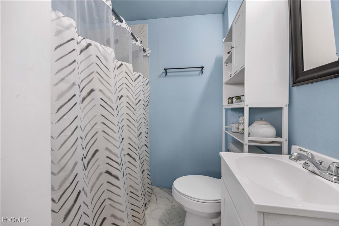 360 18th Street Northeast Naples, FL 34120 - Photo 30 of 37 a bathroom with a toilet sink and mirror