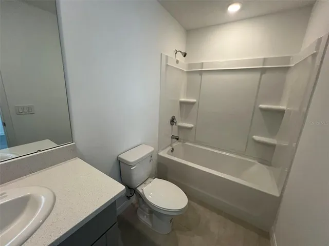 a white toilet sitting next to a bath tub