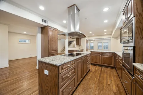 a spacious bathroom with a granite countertop sink a large mirror and a wooden floor