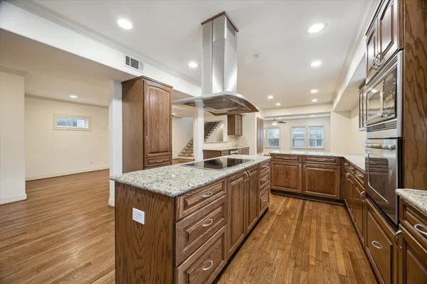 a spacious bathroom with a granite countertop sink a large mirror and a wooden floor
