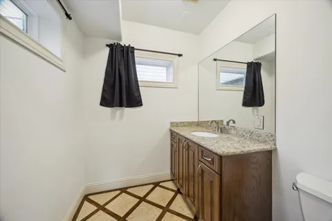 a bathroom with a sink a light fixture and a toilet