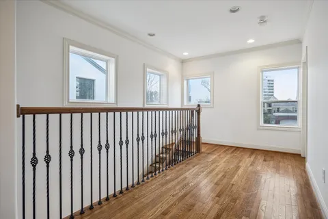 a view of a hallway with wooden floor and windows