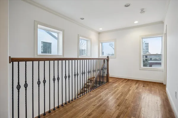 a view of a hallway with wooden floor and windows