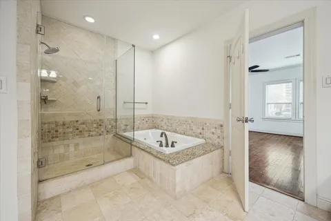 a spacious bathroom with a tub shower sink and mirror