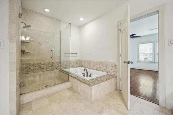 a spacious bathroom with a tub shower sink and mirror