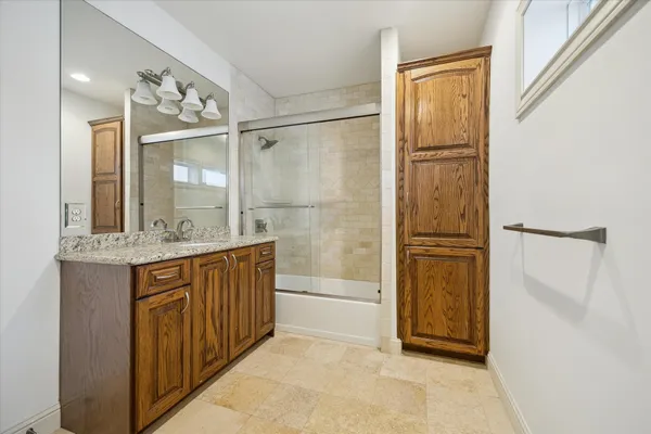 a bathroom with a granite countertop sink mirror and shower
