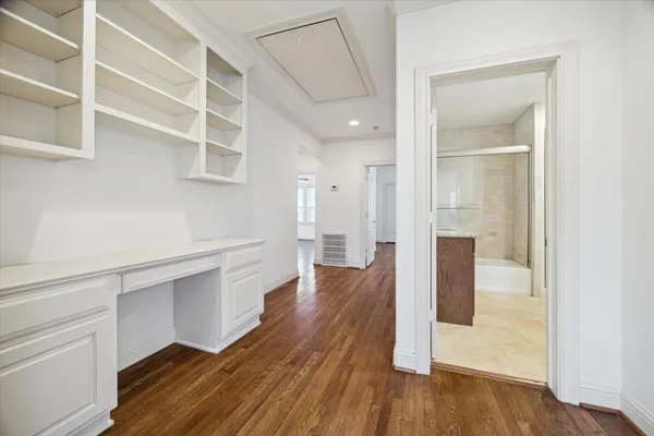 a hallway with wooden floor closet and windows