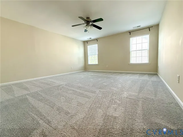 an empty room with a ceiling fan and window
