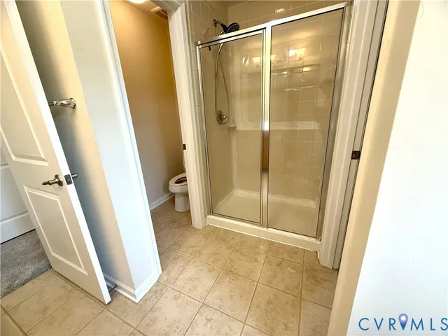 a bathroom with a glass door shower and toilet