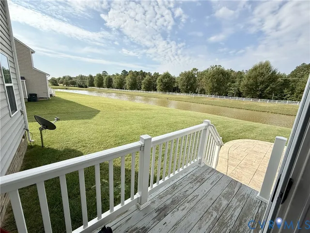 a view of a lake in middle of a field with trees