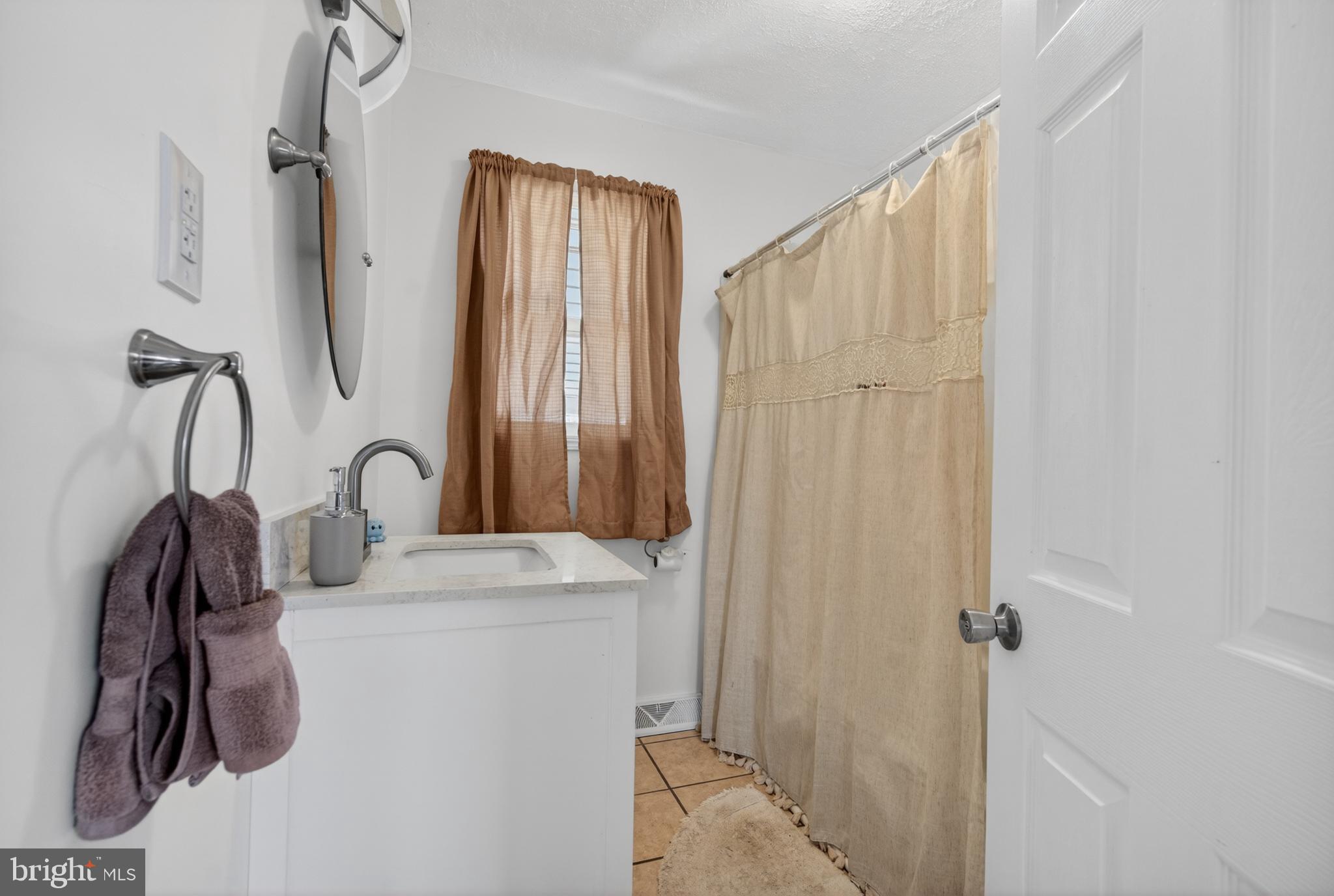 505 Monroe Street Riverside, NJ 08075 - Photo 10 of 35 a bathroom with a sink a mirror and shower