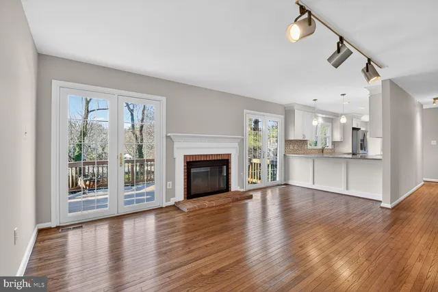 a kitchen with stainless steel appliances granite countertop a sink a stove and a wooden floors
