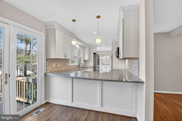 a kitchen with granite countertop a sink and stainless steel appliances