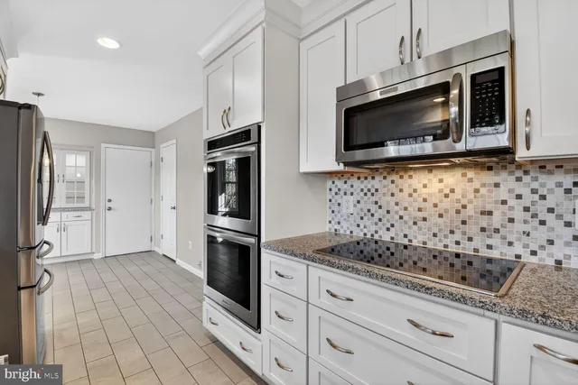 a view of empty room with windows and chandelier