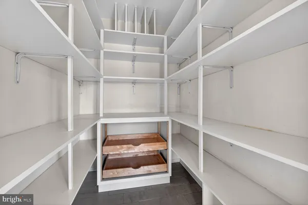a view of a hallway with wooden floor and a chandelier