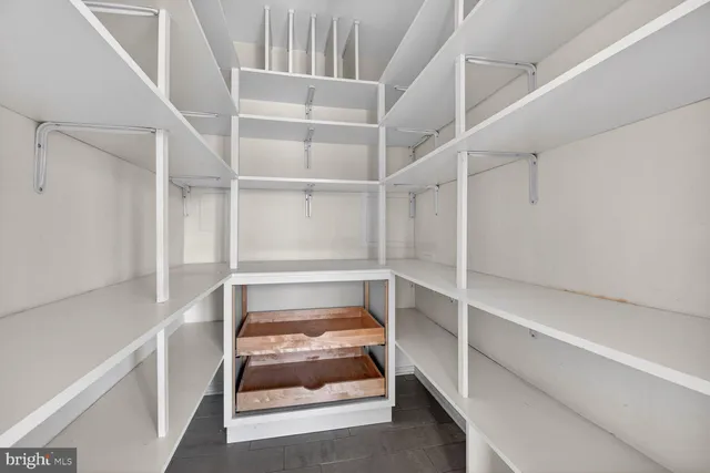 a view of a hallway with wooden floor and a chandelier