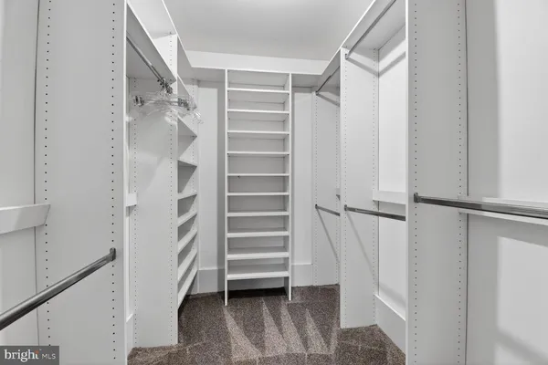 a view of an empty room and a chandelier fan