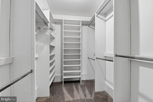 a view of an empty room and a chandelier fan