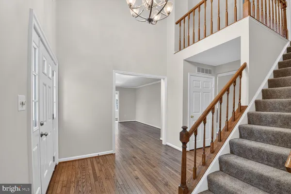 a view of staircase with wooden floor and a chandelier