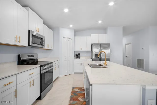 a kitchen with stainless steel appliances a stove sink microwave and cabinets