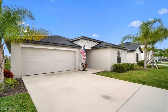 a view of a house with a yard and palm trees