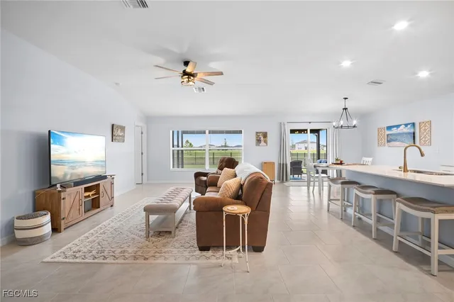 a living room with furniture a flat screen tv and kitchen view