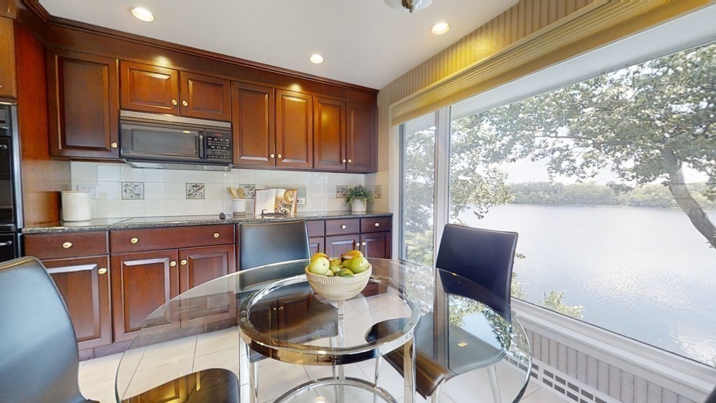 39 Beverly Road Arlington, MA 02474 - Photo 11 of 37 a kitchen with stainless steel appliances granite countertop a stove a refrigerator a sink a dining table and chairs with wooden floor