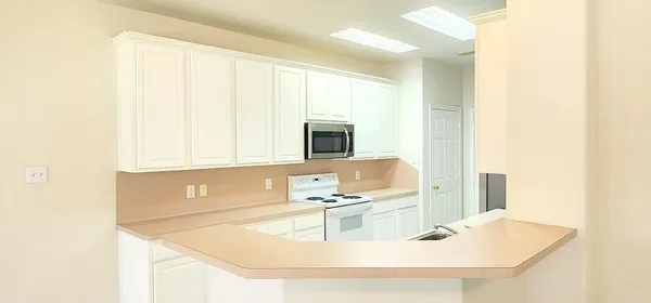 a kitchen with a sink a microwave and cabinets