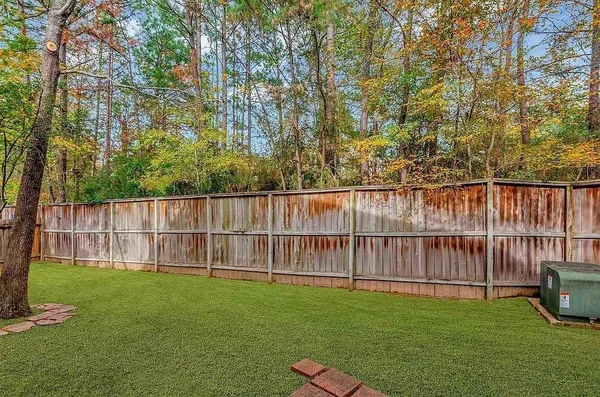 a view of a yard with wooden fence