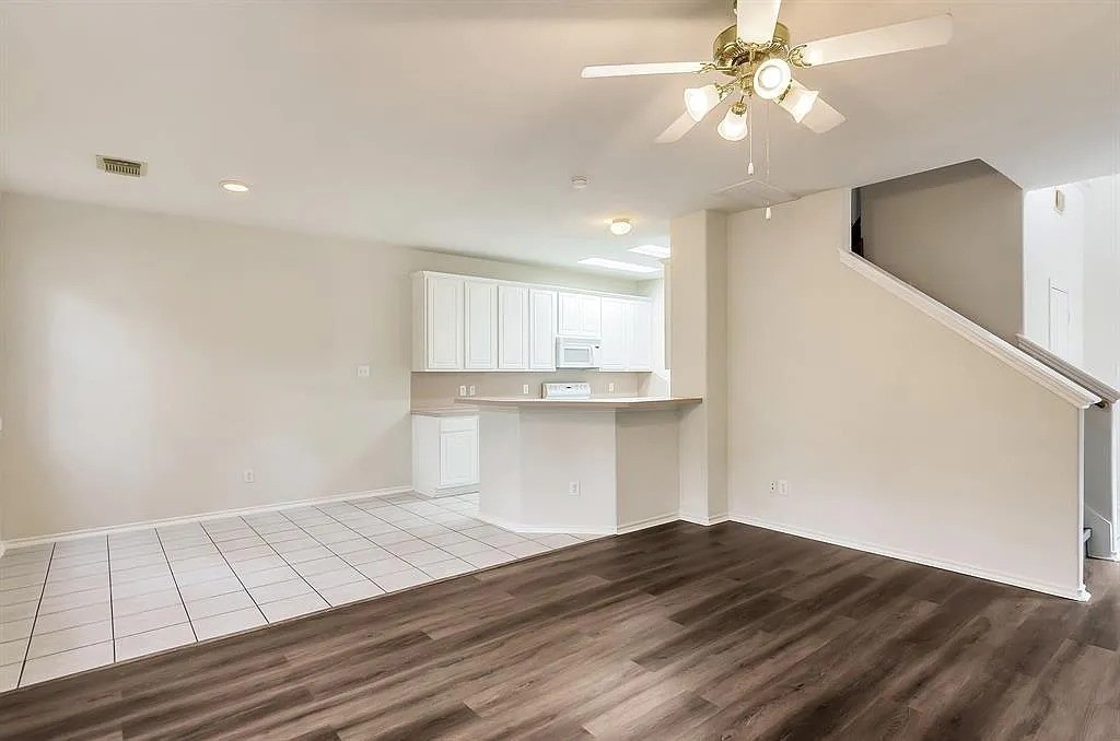 2 Peach Ridge Place The Woodlands, TX 77382 - Photo 7 of 29 a view of kitchen and empty room with wooden floor