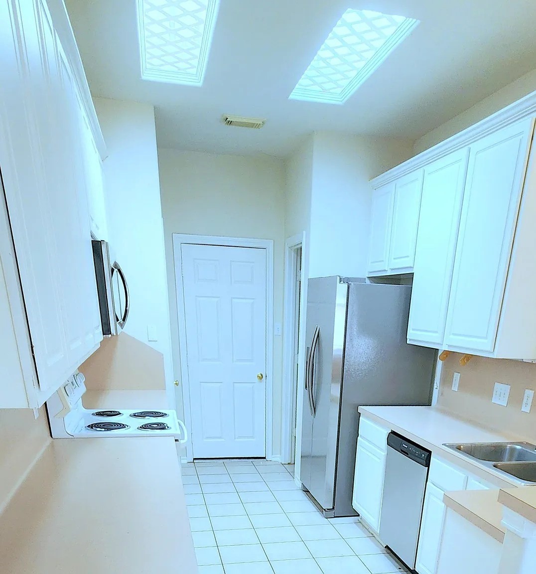 2 Peach Ridge Place The Woodlands, TX 77382 - Photo 8 of 29 a kitchen with a refrigerator and cabinets