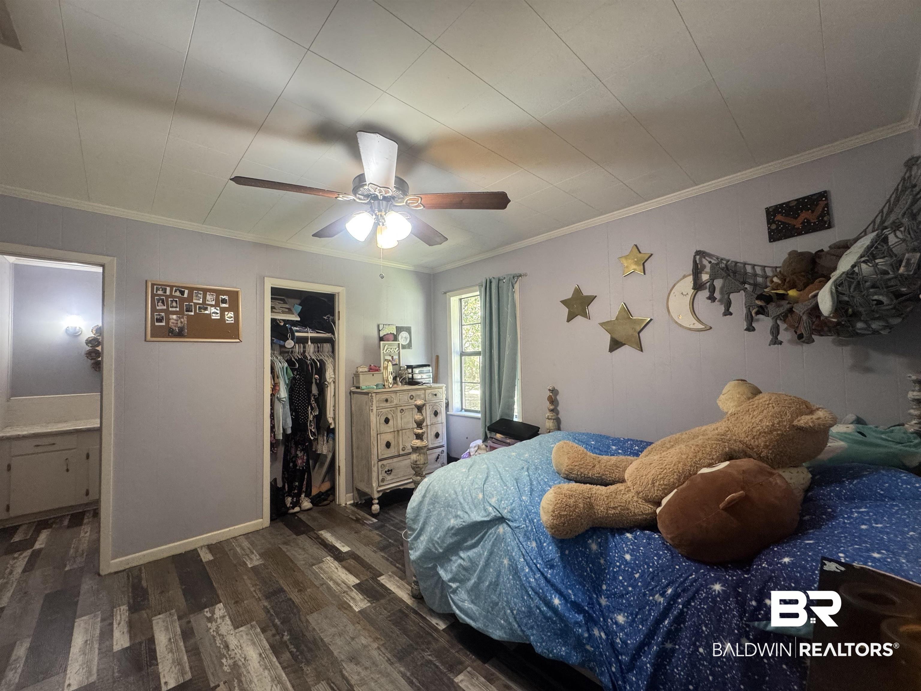 3097 Old Castleberry Road Brewton, AL 36426 - Photo 8 of 49 Bedroom #2 featuring dark hardwood / wood-style floors, a closet, a spacious closet, crown molding, and ceiling fan