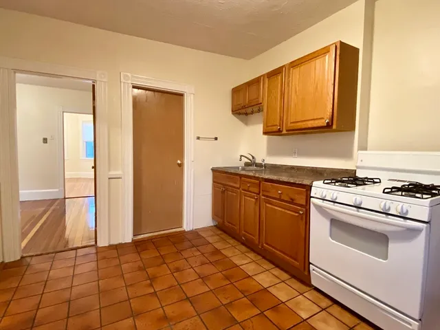 a kitchen with a stove top oven cabinets and a refrigerator