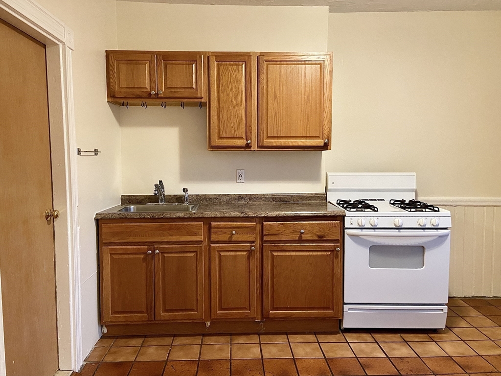 257 Beacon Street, Unit 3 Somerville, MA 02143 - Photo 5 of 15 a kitchen with stainless steel appliances granite countertop a stove a sink and a refrigerator