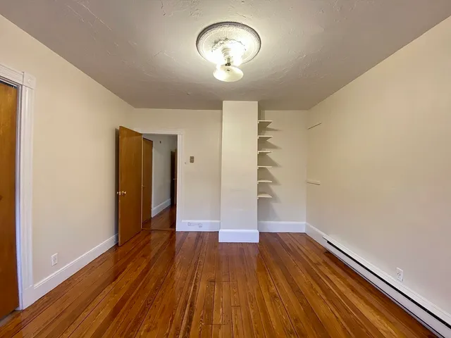 a view of empty room with wooden floor