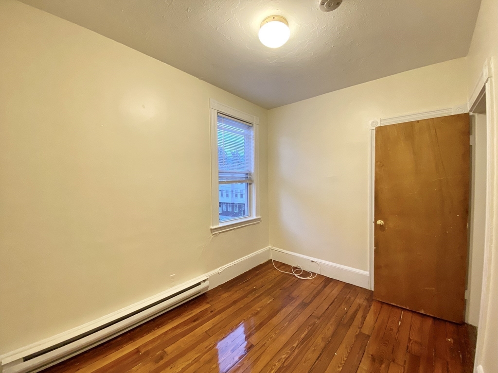 257 Beacon Street, Unit 3 Somerville, MA 02143 - Photo 8 of 15 an empty room with wooden floor