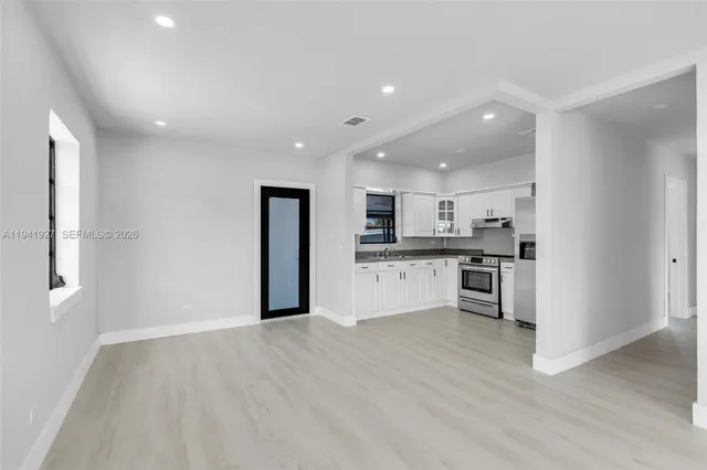 a view of kitchen with granite countertop refrigerator and sink