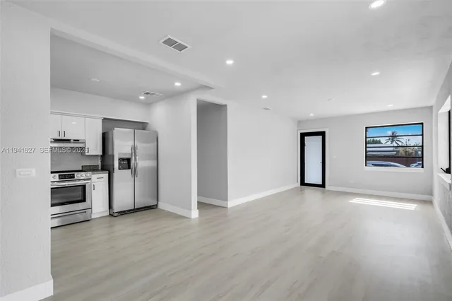 a view of a kitchen with refrigerator stove and wooden floor