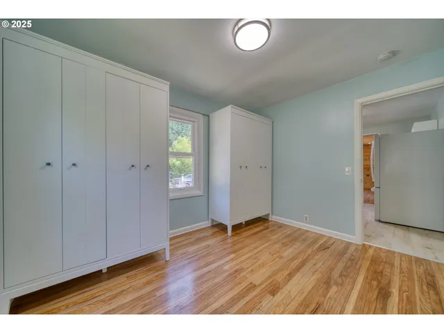 a view of an empty room with closet and a window