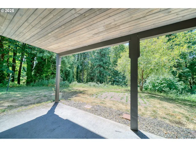 a view of a room with a large window and wooden fence