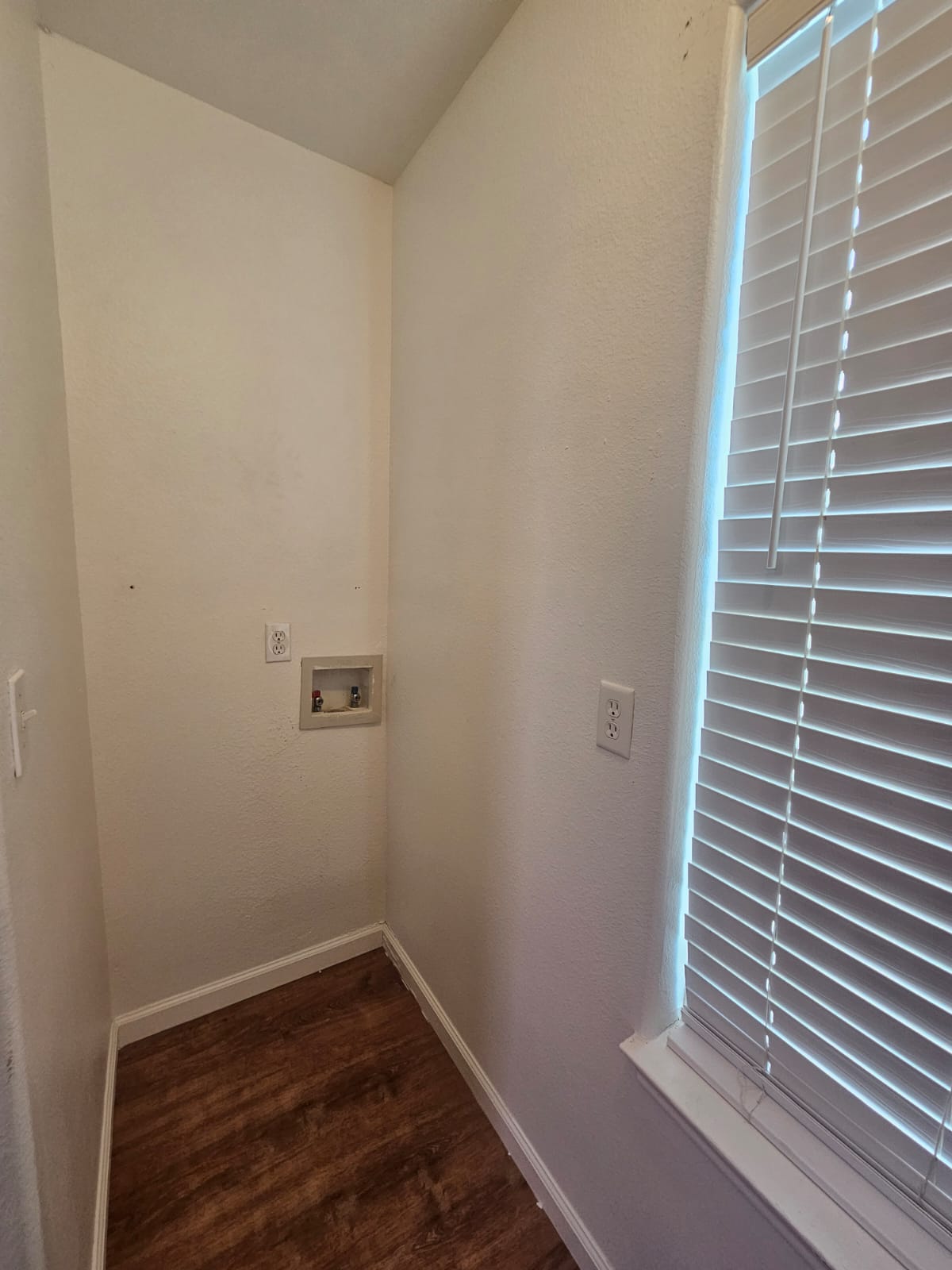 606 Trinity Street Lockhart, TX 78644 - Photo 18 of 23 Ready for your appliances, this utility room features a window for natural light and durable flooring.