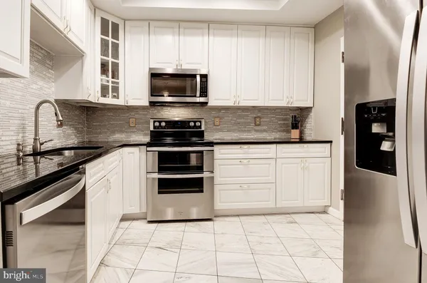 a kitchen with granite countertop a stove sink and cabinets