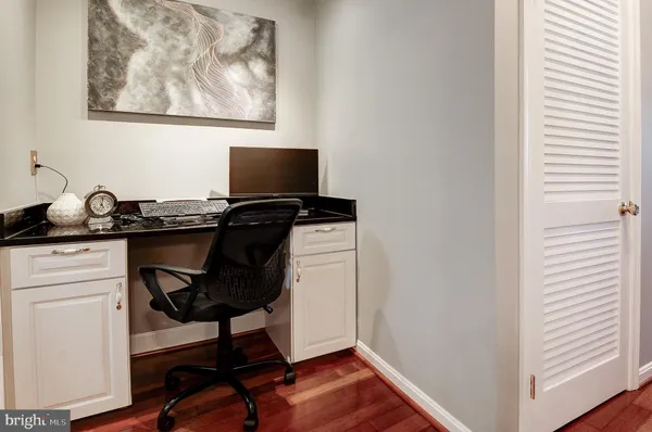 a view of a workspace with furniture and a window