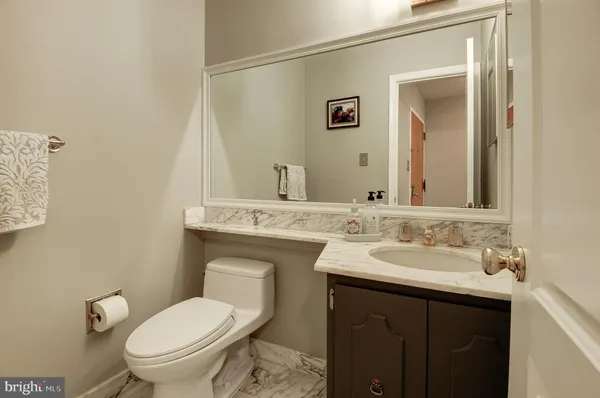 a bathroom with a granite countertop toilet sink and mirror